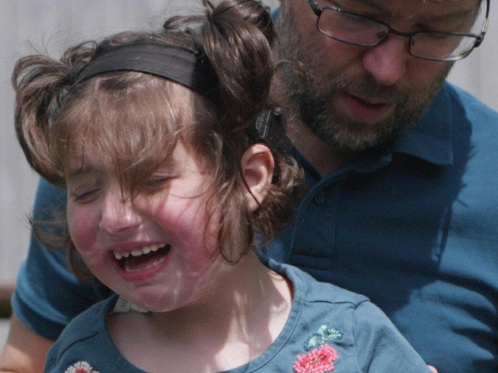 A young mito patient crying and being embraced by her father