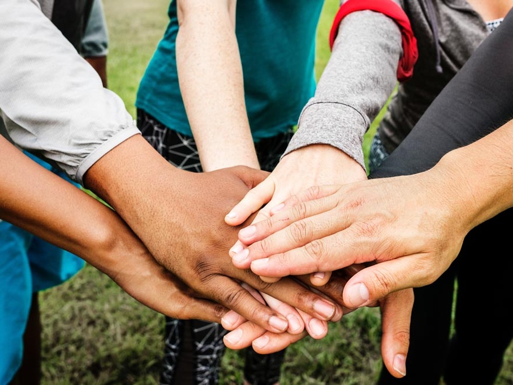 A group of people with their hands on top of each other