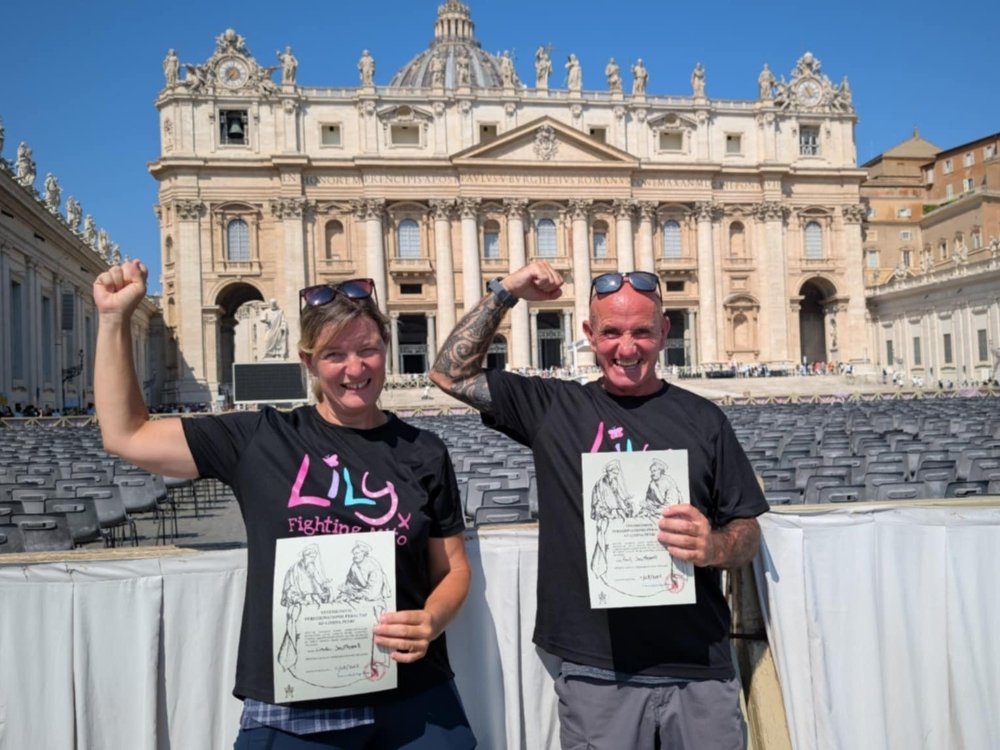 A couple wearing Lily Foundation tops standing in Rome at the finish of the Via Francigena
