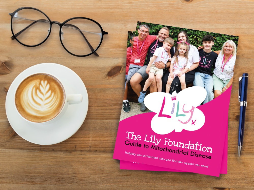 A copy of the Lily Foundation guide to mitochondrial disease on a table with a coffee and a pair of glasses