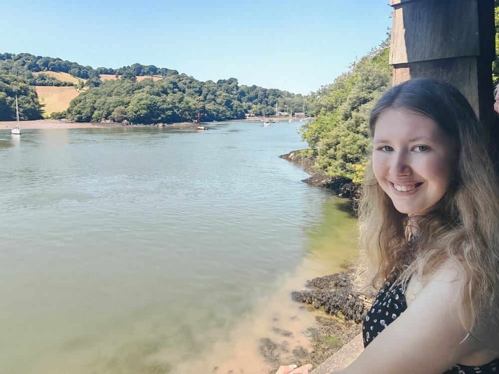 Mitochondrial disease patient India standing on the banks of a wide river