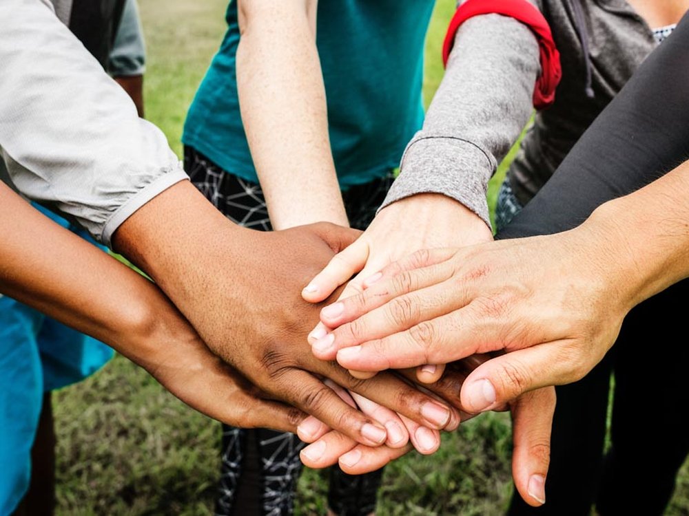 A group of people with their hands on top of each other