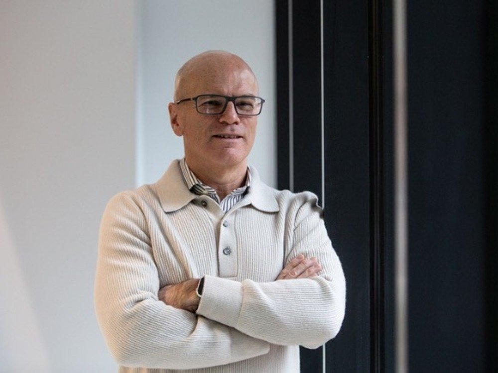 Prof Bobby McFarland standing with his arms crossed, wearing a cream jumper