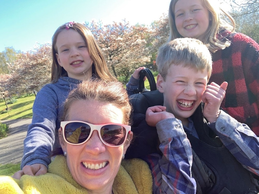 Happy family with a young mitochondrial disease patient outside in the sunshine