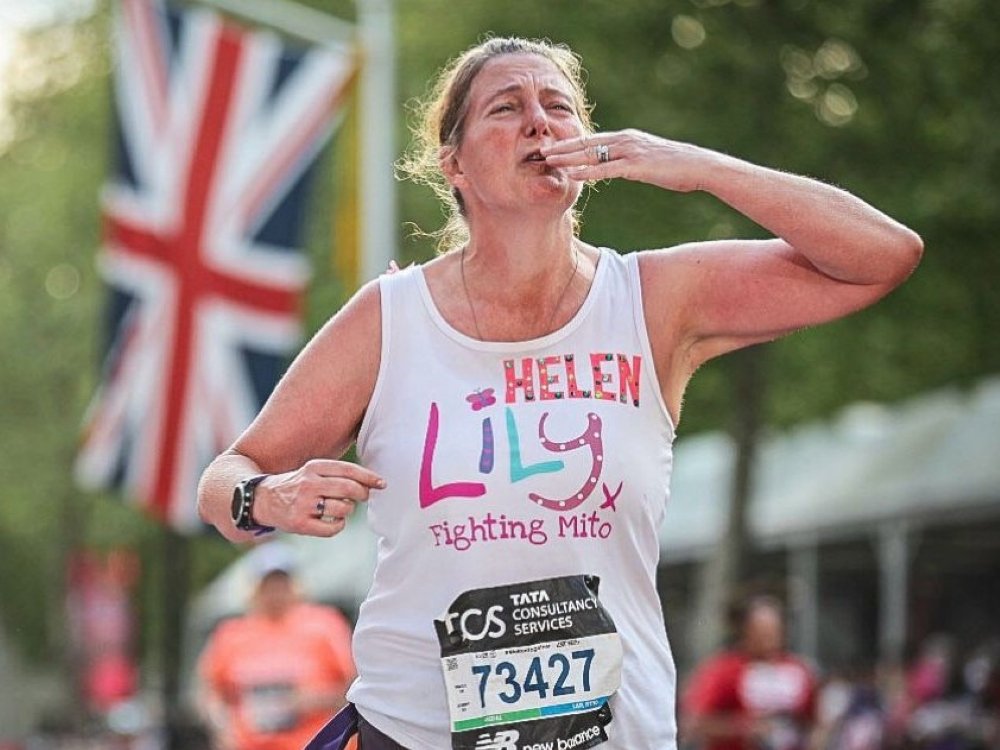 A lady in a Lily vest kissing the air at the London Marathon
