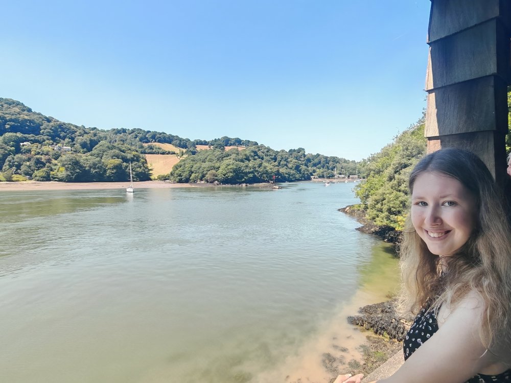 Mitochondrial disease patient India standing on the banks of a wide river