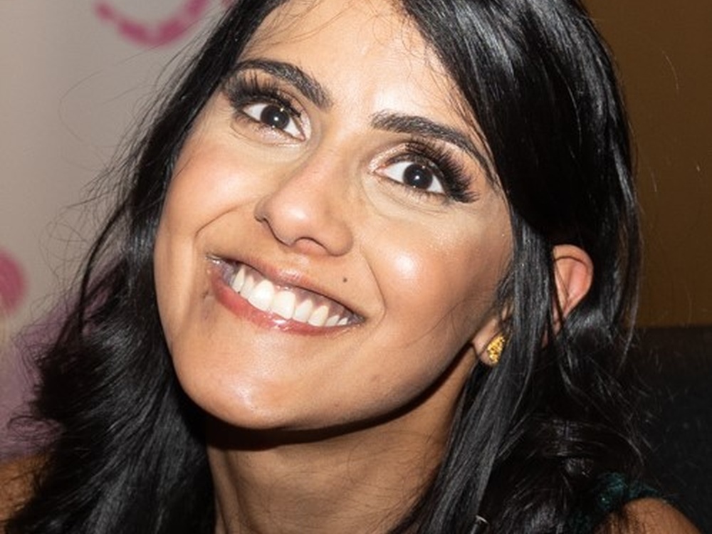 A woman with long dark shiny hair smiling