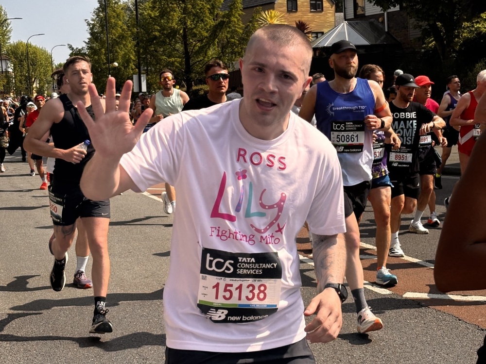 A Lily runner at the London Marathon waving to spectators