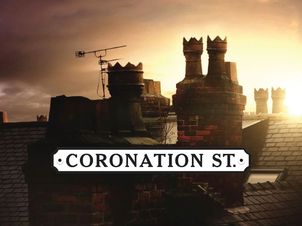 Chimney's on roof tops at dusk with a Coronation Street sight in front