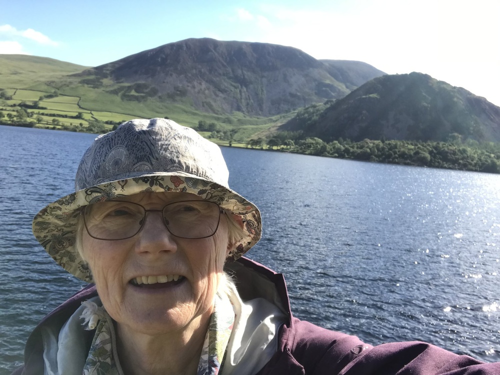 Prof Joanna Poulton with a lake and grassy mountains in the background