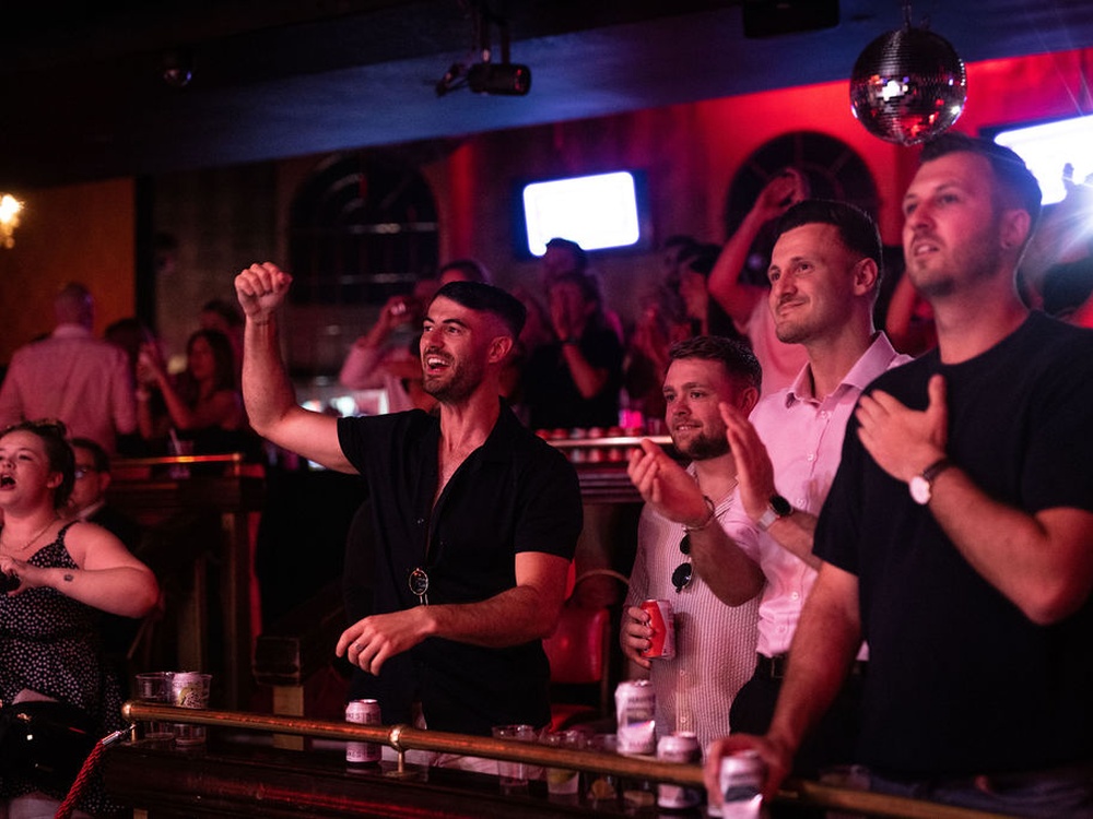 Supporters on the balcony cheer on the boxers at the Lily fight night