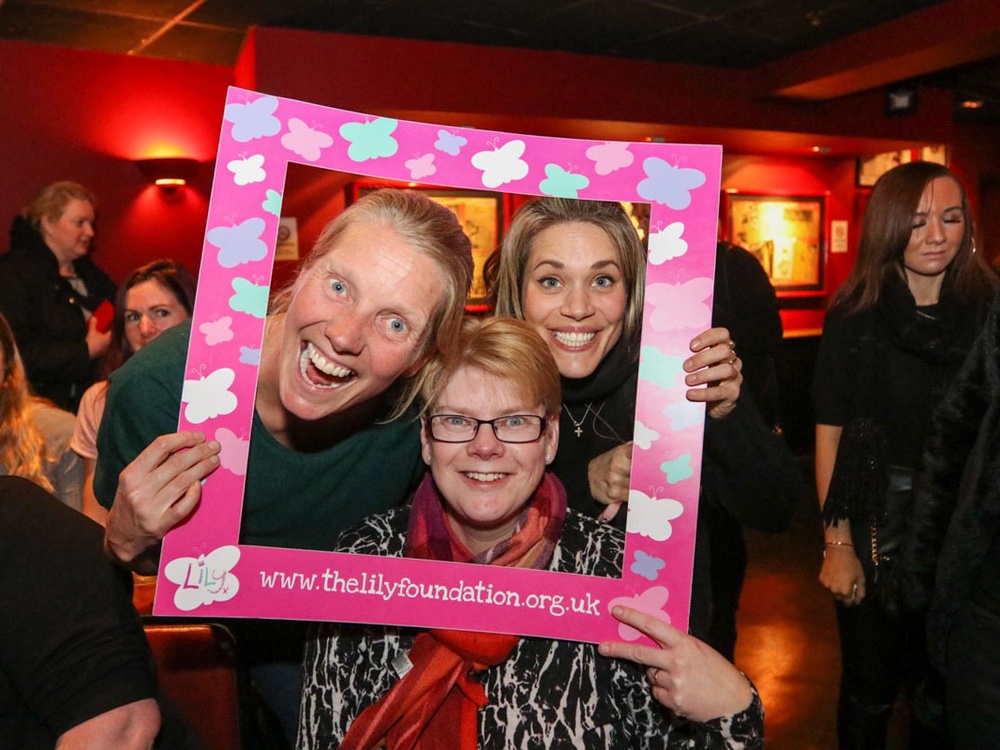 Lily Foundation supporters with their heads in a frame covered in butterflies
