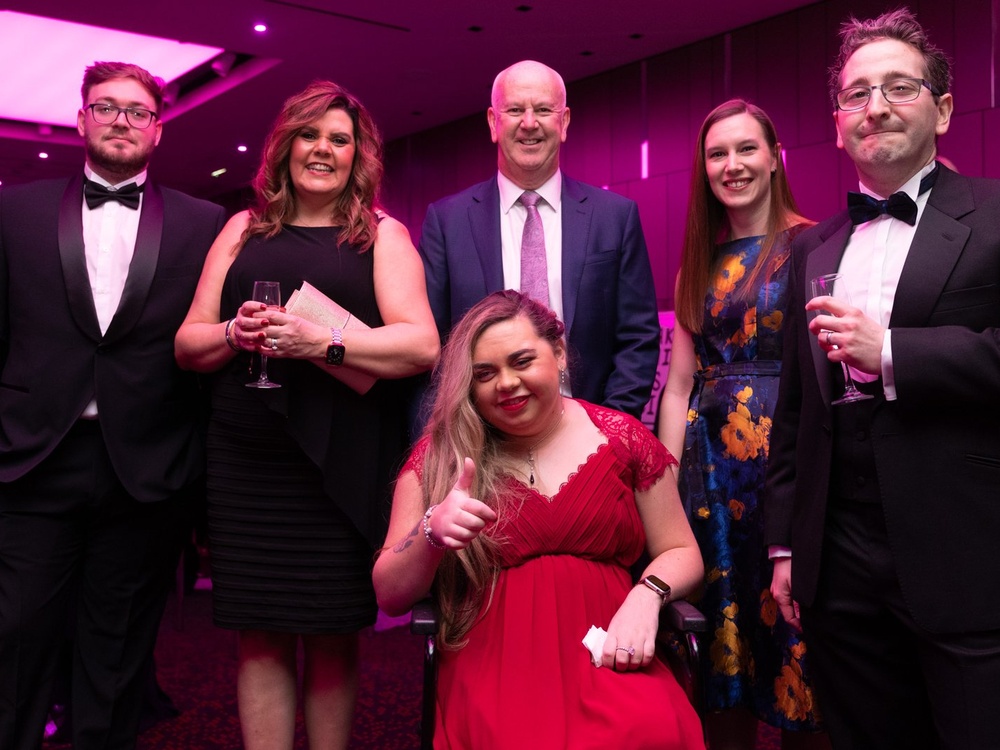 A group of guests, including one in a wheelchair, in their party clothes