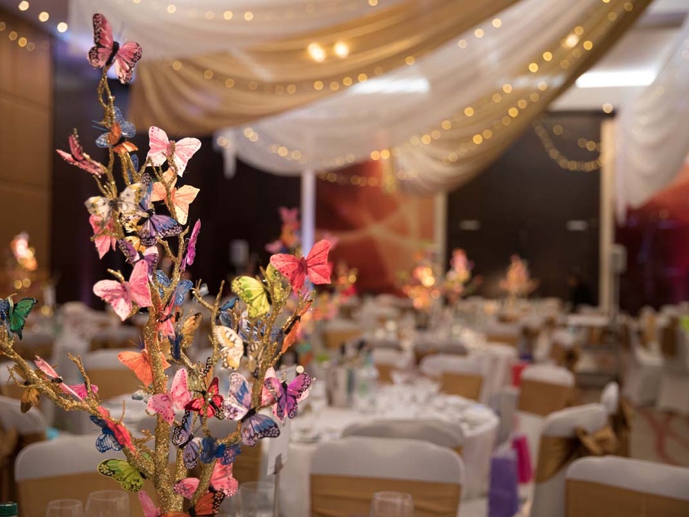 Close-up of sparkly butterfly decorations on a table at the Lily ball