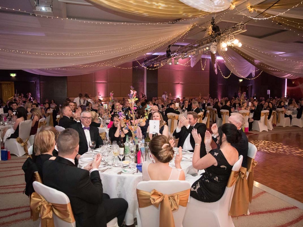 The ballroom filled with people sitting at tables at the Lily charity ball