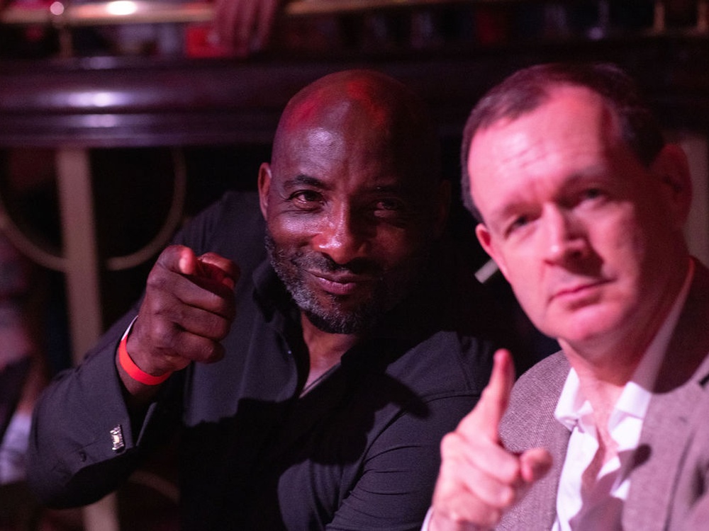 Close up of two men pointing at the camera and looking stern
