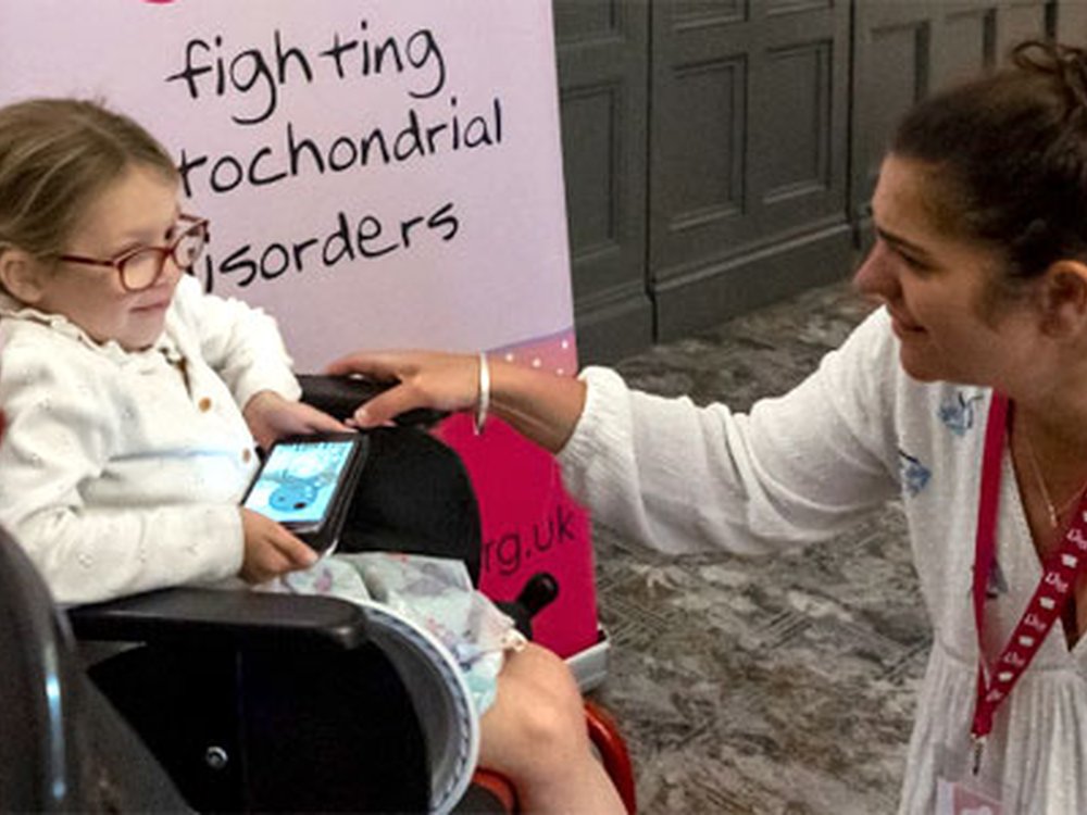 Celebrating 15 years of...Lily Fundraising - Young mito warrior in a wheelchair at the Lily Foundation family weekend talking to founder Liz