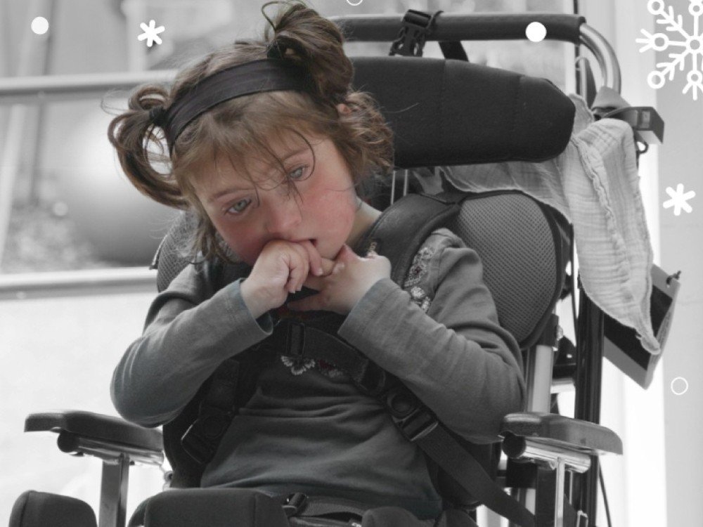 It takes courage to face mitochondrial disease - A young mito patient in a wheelchair holding her hands up to her face