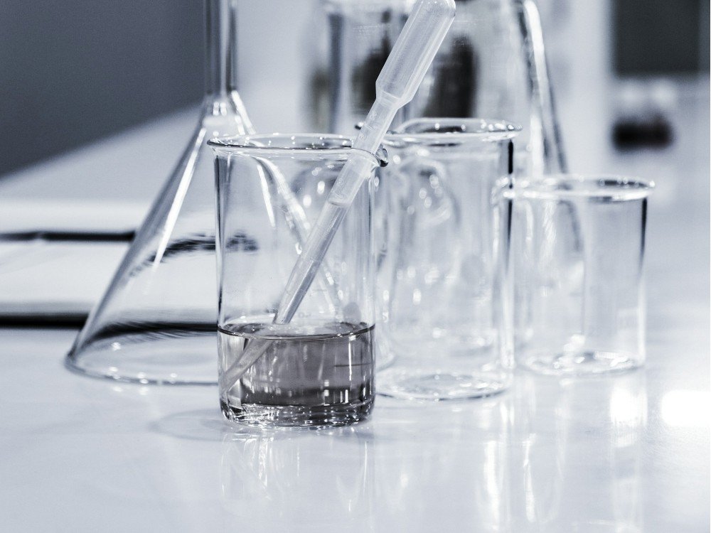 Three clear science beakers placed on a work surface