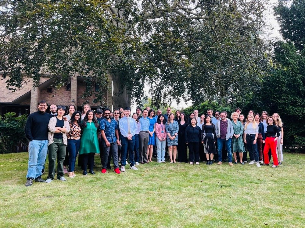 A group of mitochondrial researchers from Cambridge standing together on aa lawn