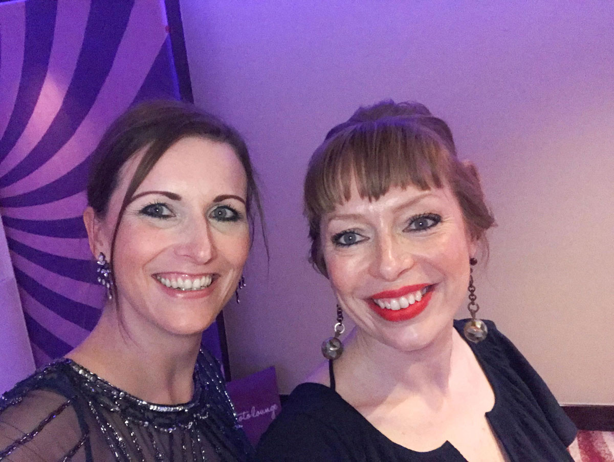 head shot of two women smiling into the camera