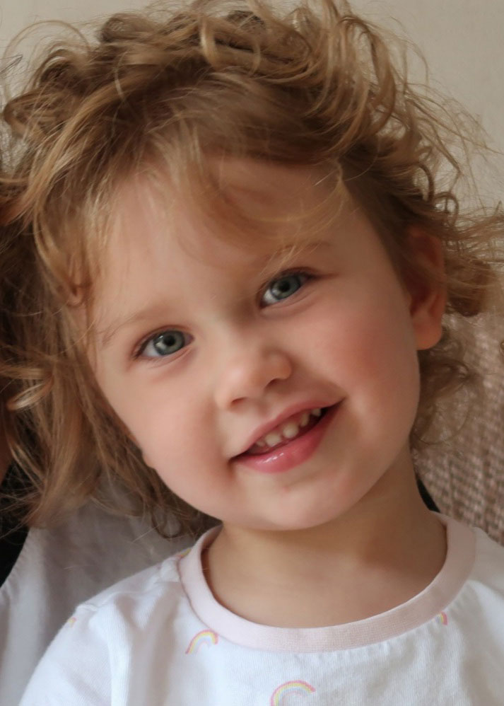 Young girl, smiling with curly blonde hair